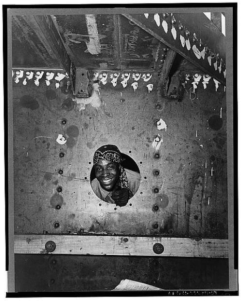 Building the SS Frederick Douglass. Smiling from the porthole is rivet heater Willie Smith. (Photograph by Roger Smith, Office of War Information, Library of Congress Prints and Photographs Division)